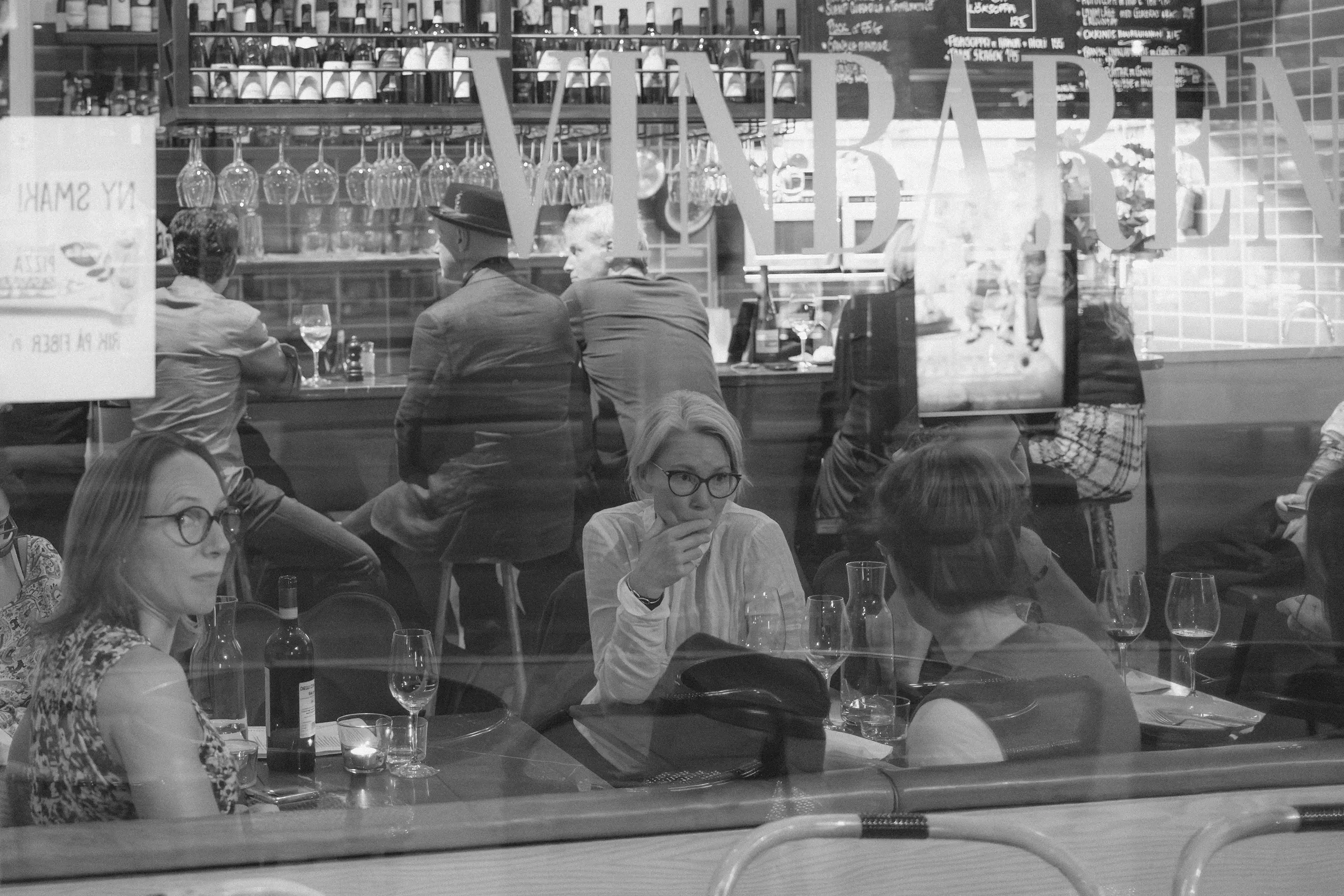 A group of women through the window of a wine bar