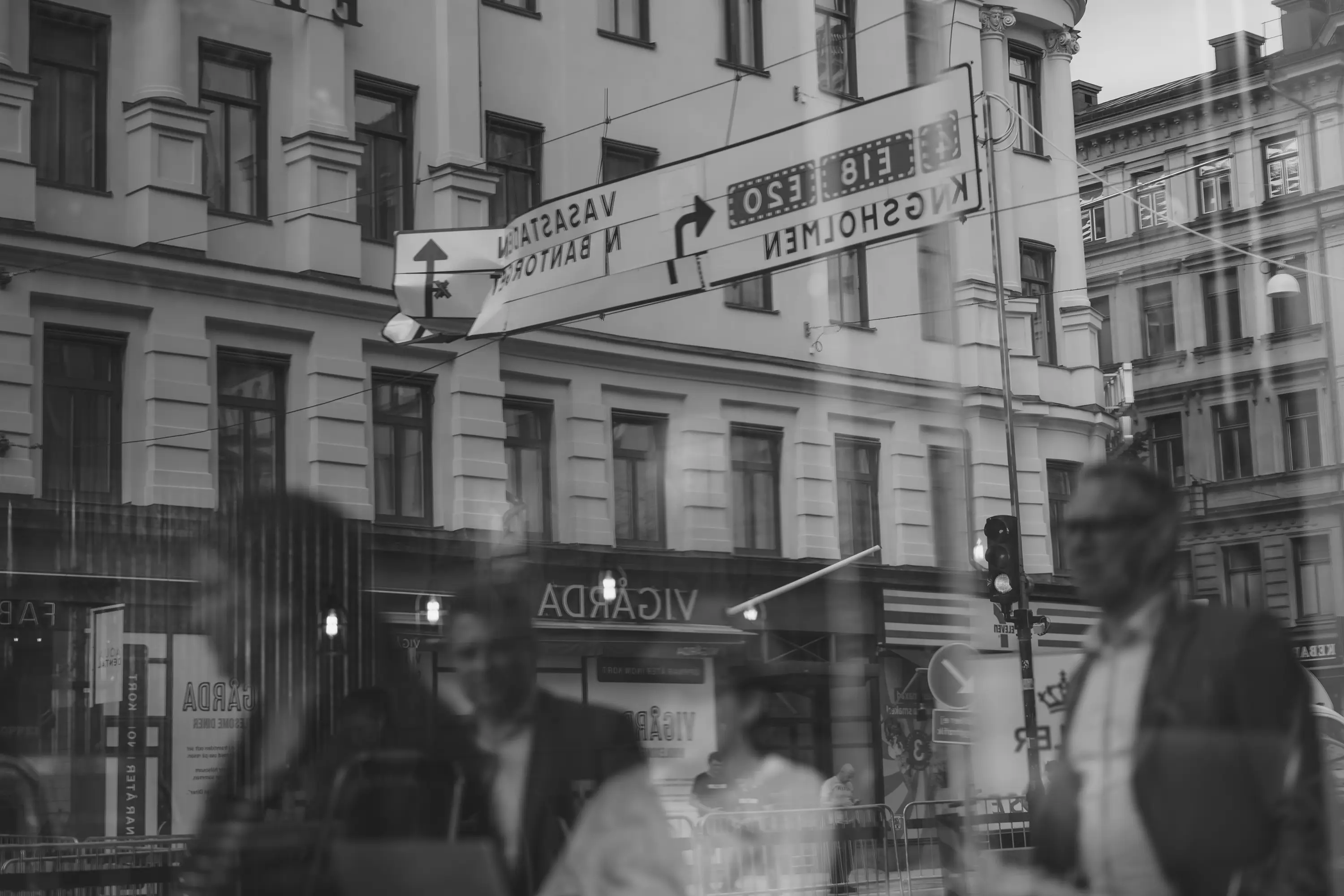 Pedestrians reflected through the window in Vasagatan